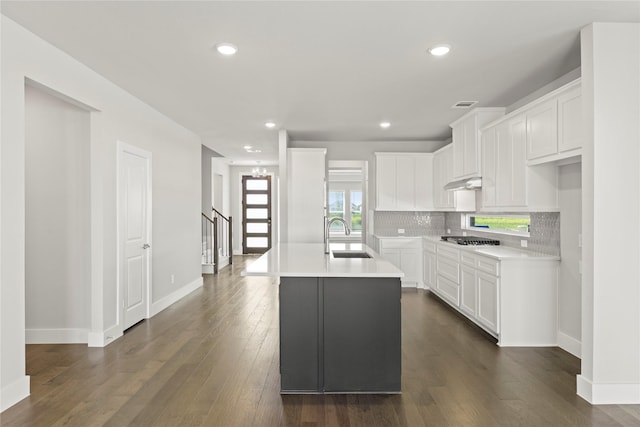 1590 Marburg Ln, Frisco, TX 75036 - kitchen with a sink, under cabinet range hood, decorative backsplash, stainless steel gas cooktop, and baseboards