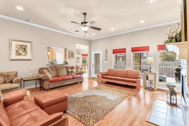 living room featuring hardwood / wood-style flooring, ceiling fan, and crown molding