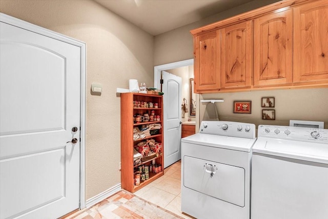 laundry room with cabinets, washing machine and dryer, and light tile patterned flooring