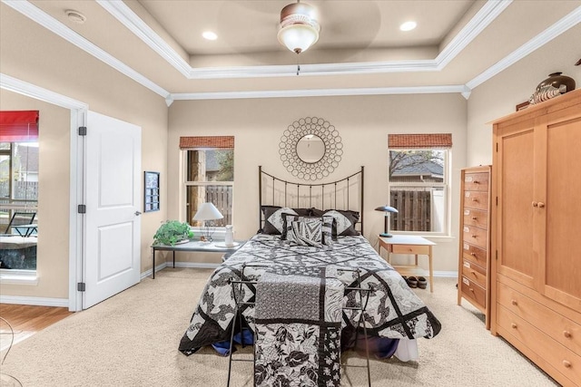 carpeted bedroom with ceiling fan, crown molding, and a tray ceiling