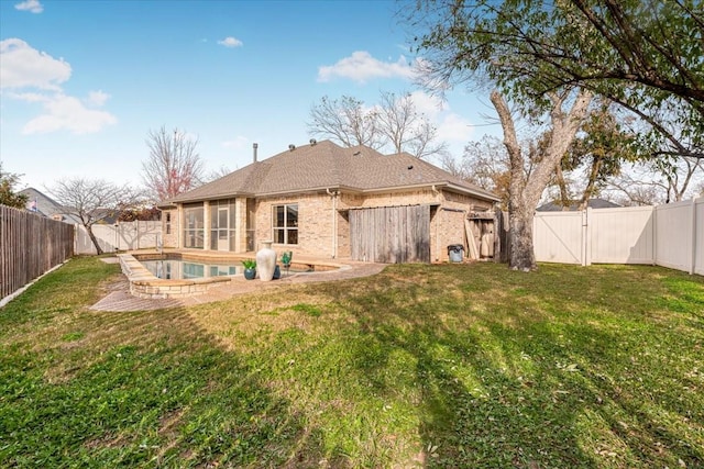 rear view of house featuring a fenced in pool and a lawn