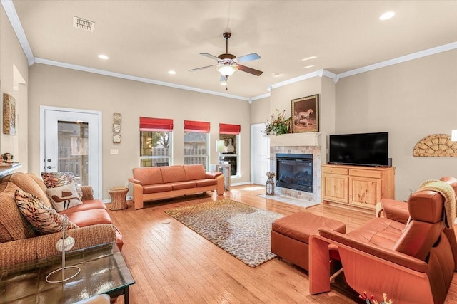 living room featuring ceiling fan, ornamental molding, and light hardwood / wood-style flooring