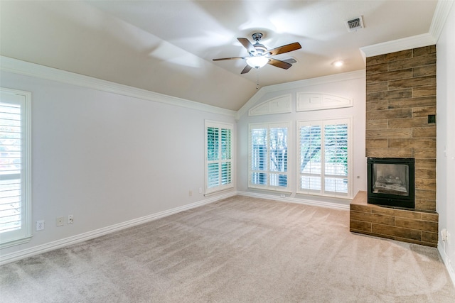 unfurnished living room with crown molding, vaulted ceiling, light colored carpet, and a large fireplace