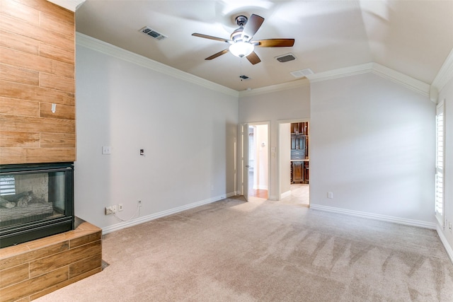 unfurnished living room with crown molding, ceiling fan, carpet, a large fireplace, and vaulted ceiling