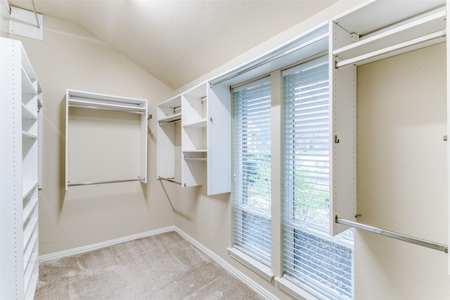 spacious closet featuring light colored carpet and lofted ceiling