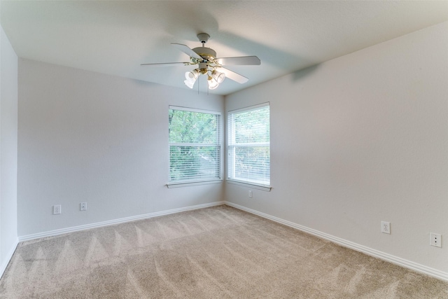 carpeted spare room featuring ceiling fan