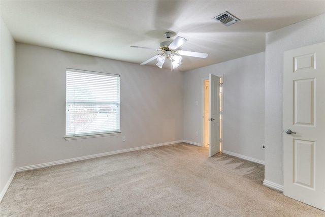 carpeted spare room with ceiling fan