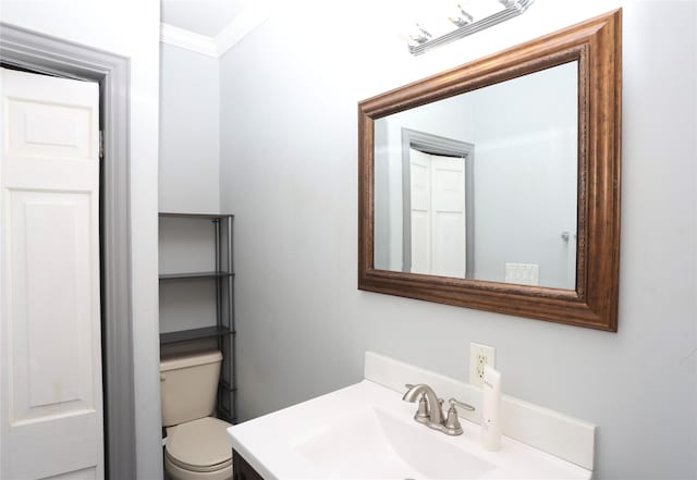 bathroom with vanity, toilet, and ornamental molding