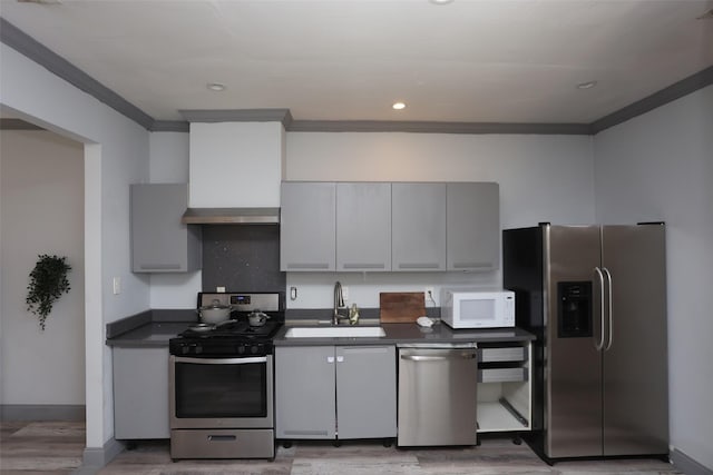 kitchen with gray cabinetry, sink, appliances with stainless steel finishes, and light hardwood / wood-style flooring