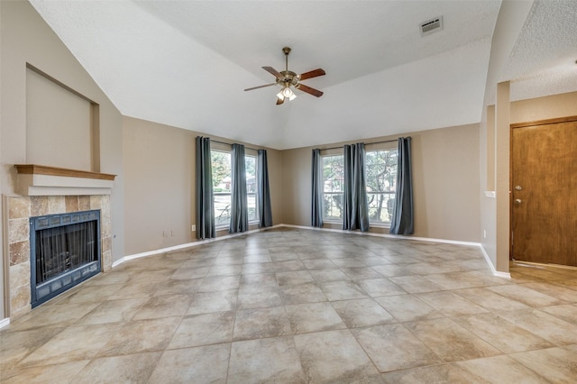 unfurnished living room featuring ceiling fan, lofted ceiling, a tiled fireplace, and light tile patterned floors