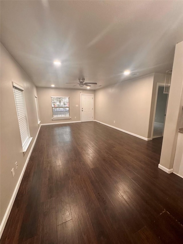 unfurnished living room featuring dark hardwood / wood-style floors and ceiling fan