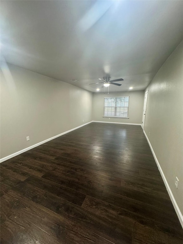 empty room featuring dark wood-type flooring and ceiling fan