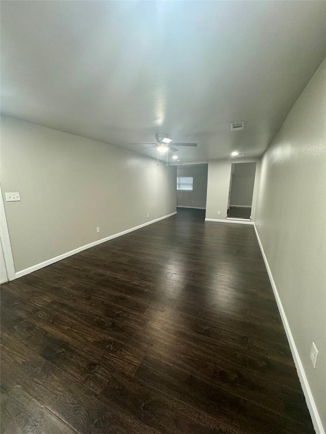 unfurnished room featuring dark wood-type flooring and ceiling fan