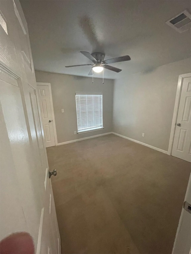 unfurnished bedroom with ceiling fan and carpet