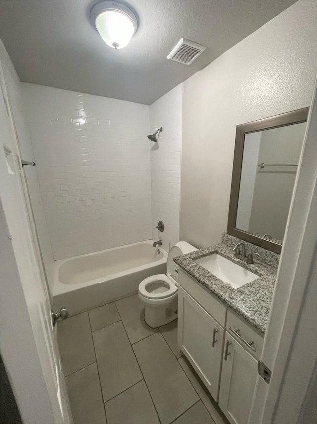 full bathroom with vanity, tiled shower / bath combo, tile patterned floors, and toilet