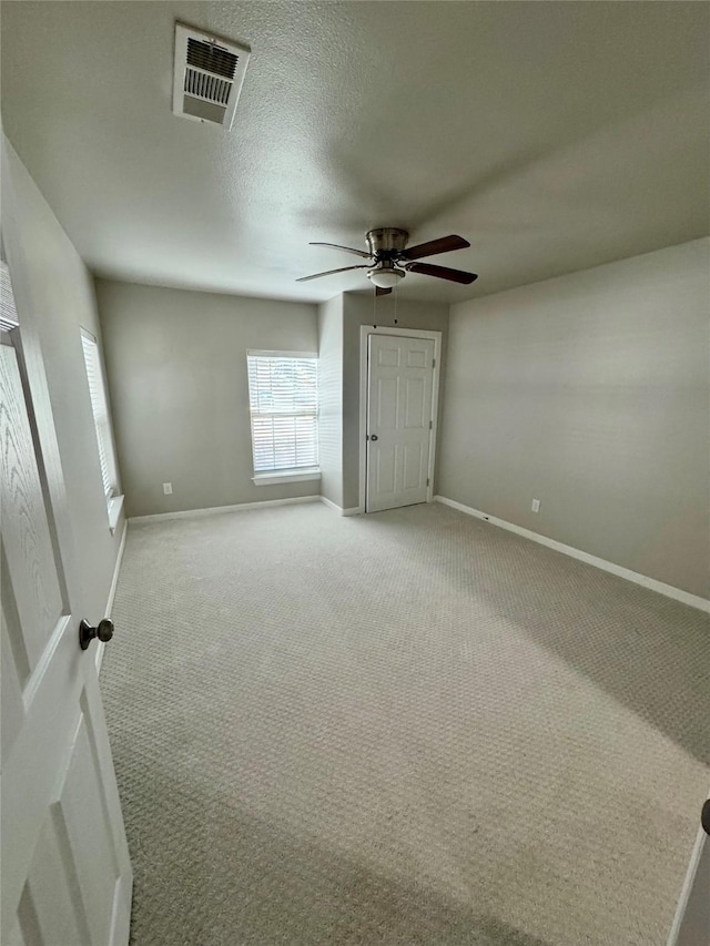 unfurnished bedroom featuring ceiling fan, carpet, and a textured ceiling