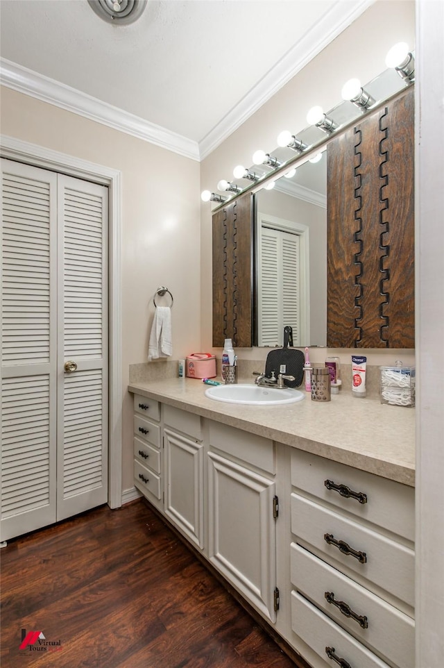 bathroom featuring ornamental molding, wood-type flooring, and vanity