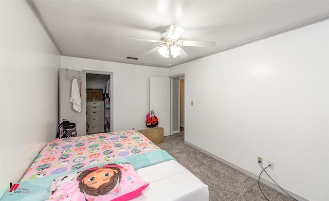 carpeted bedroom featuring ceiling fan, ornamental molding, and a closet