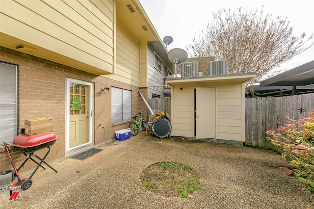 rear view of property with cooling unit and a patio