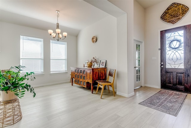 entrance foyer with an inviting chandelier, a healthy amount of sunlight, and light hardwood / wood-style floors