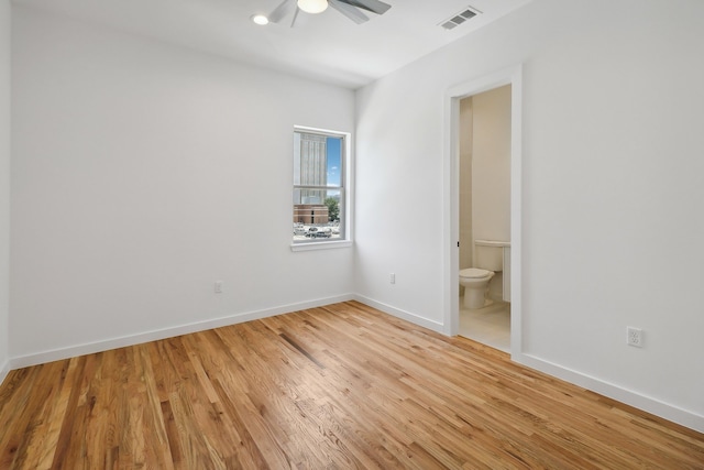 unfurnished bedroom with ceiling fan, ensuite bath, and light hardwood / wood-style flooring