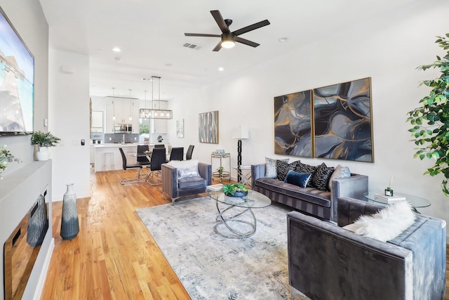 living room with ceiling fan and light hardwood / wood-style floors