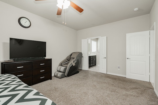 bedroom featuring ceiling fan, light colored carpet, and ensuite bath