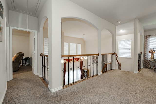 hall with light colored carpet