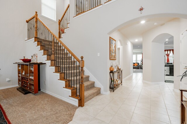 kitchen with light stone countertops, sink, backsplash, kitchen peninsula, and light tile patterned floors