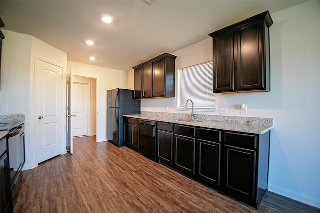 kitchen with light stone countertops, sink, dark hardwood / wood-style floors, dark brown cabinets, and black appliances