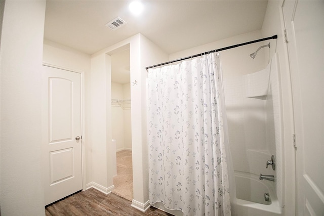 bathroom featuring hardwood / wood-style floors and shower / bathtub combination with curtain