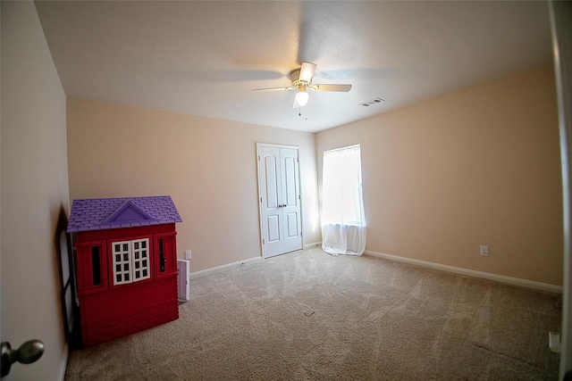 empty room with ceiling fan and carpet