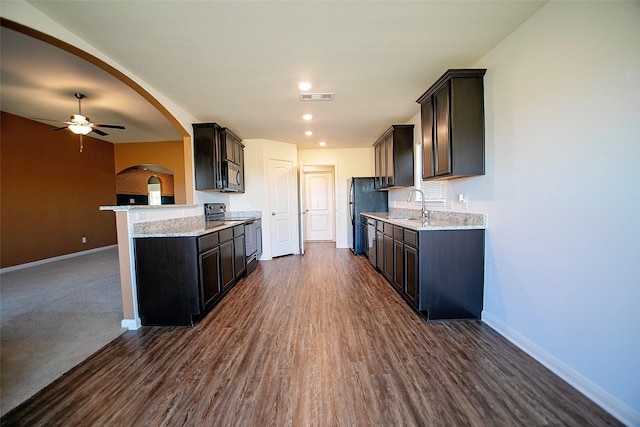 kitchen featuring ceiling fan, sink, stainless steel appliances, dark hardwood / wood-style floors, and kitchen peninsula