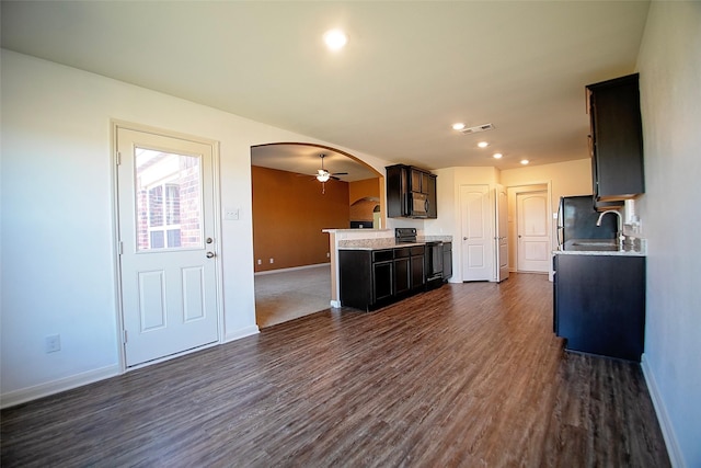 kitchen featuring dark brown cabinetry, ceiling fan, sink, dark wood-type flooring, and black appliances