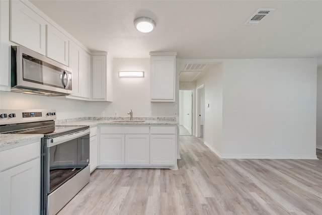 kitchen featuring light stone countertops, sink, stainless steel appliances, white cabinets, and light wood-type flooring