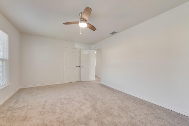 carpeted empty room featuring ceiling fan