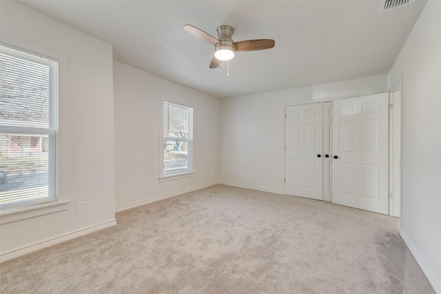 unfurnished bedroom with ceiling fan, a closet, and light carpet