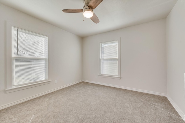 empty room featuring plenty of natural light, ceiling fan, and light carpet