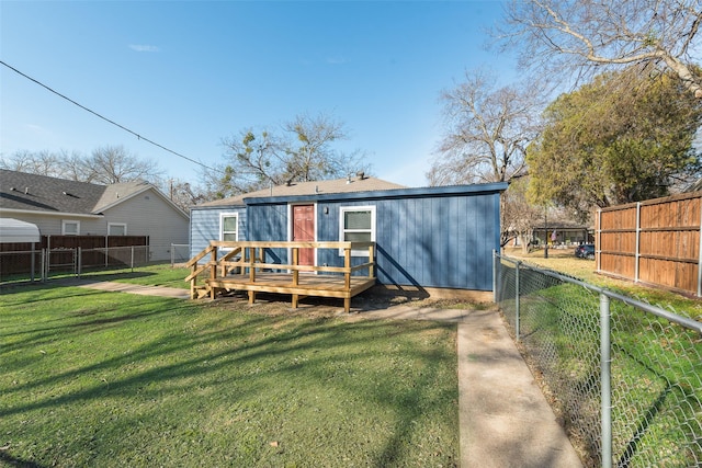 back of house featuring a lawn and a deck