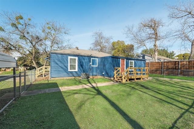 rear view of house with a lawn and a wooden deck