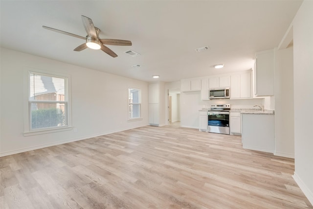 unfurnished living room with ceiling fan, sink, and light hardwood / wood-style flooring