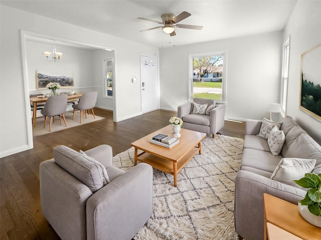 living room with hardwood / wood-style floors and ceiling fan with notable chandelier