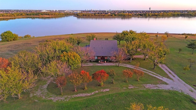 aerial view at dusk featuring a water view