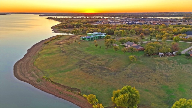 aerial view at dusk featuring a water view