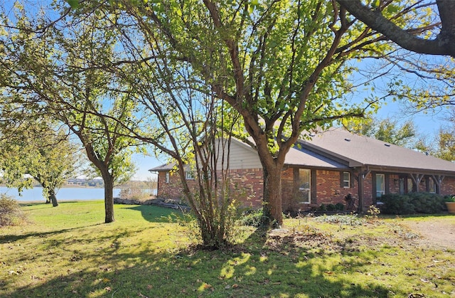 view of property exterior with a lawn and a water view