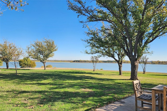 surrounding community featuring a lawn and a water view