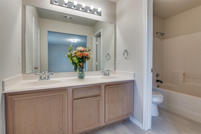 full bathroom with hardwood / wood-style flooring, vanity, toilet, and tub / shower combination