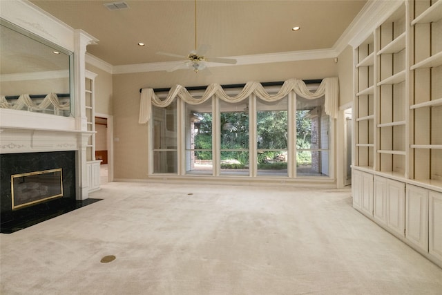 unfurnished living room with ceiling fan, light colored carpet, ornamental molding, and a fireplace