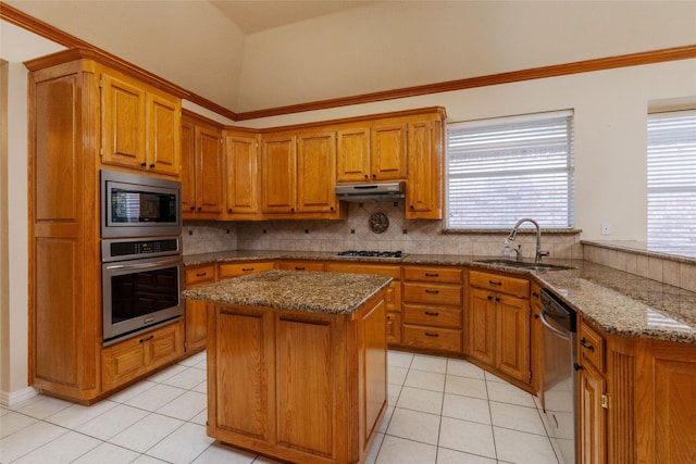 kitchen with sink, light tile patterned flooring, vaulted ceiling, a kitchen island, and appliances with stainless steel finishes