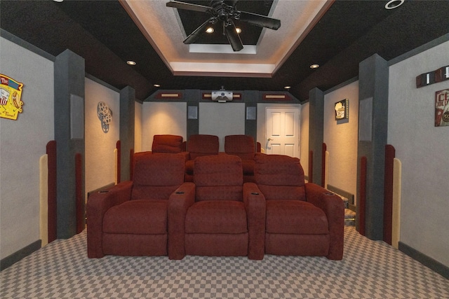 home theater with ceiling fan and a tray ceiling